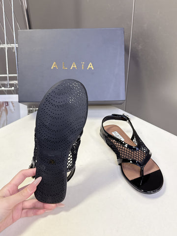 ALAIA 26S FLAT MESH THONG SANDALS IN BLACK PATENT CALFSKIN